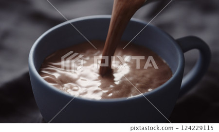 pour hot chocolate into blue cup closeup 124229115