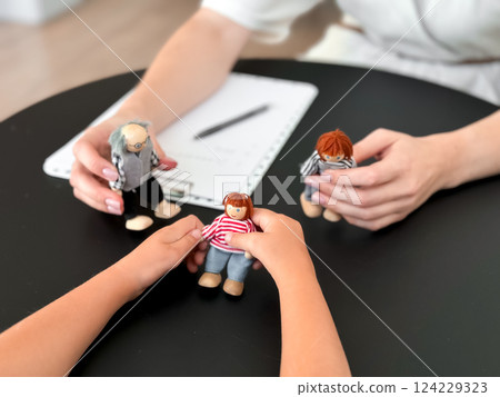 Child therapy session with puppet family interaction on table 124229323