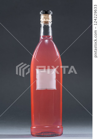 bottle with homemade alcohol tincture or liquor, mockup with empty label, berries and rose 124229633