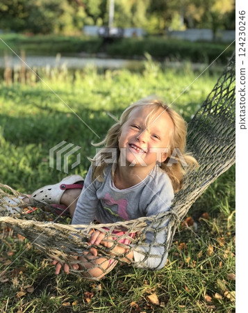 Happy Child Playing in a Hammock Outdoors Happy Child Playing in a Hammock Outdoors 124230246