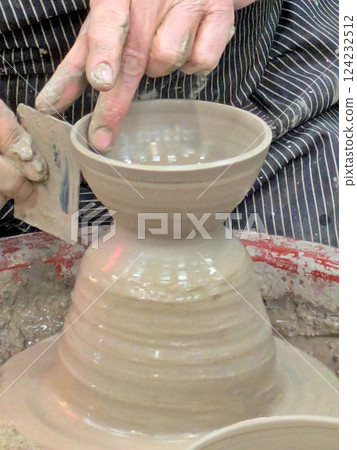Hand's of pottery maker on potter's wheel Hand's of pottery maker on potter's wheel 124232512