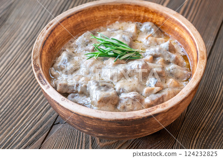 Hearty beef stroganoff in rustic bowl, garnished with fresh aromatic rosemary 124232825