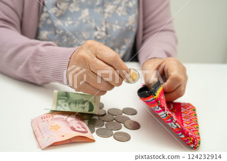 Asian senior or elderly old lady woman holding counting coin money in bag. Poverty, saving problem in retirement. Asian senior or elderly old lady woman holding counting coin money in bag. Poverty, saving problem in retirement. 124232914