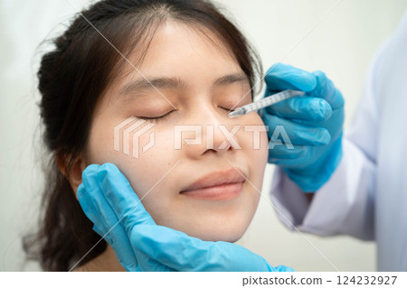 Asian woman receiving plastic surgery shape of nose performed on face. Asian woman receiving plastic surgery shape of nose performed on face. 124232927