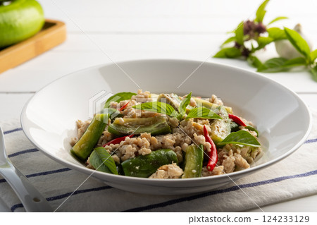 Asian style clean food.Stir fried long green eggplant with ground chicken breast and basil leaves in white plate. 124233129
