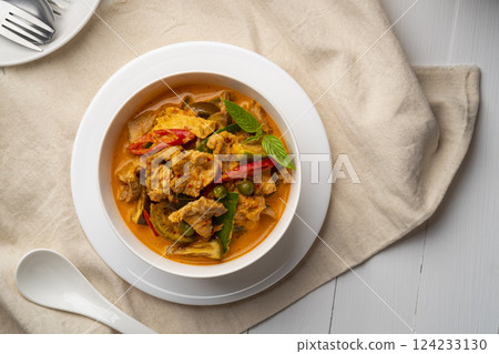 Thai curry red soup,Thailand tradition menu,boiled sliced pork with red curry paste and coconut milk in white bowl.Top view Thai curry red soup,Thailand tradition menu,boiled sliced pork with red curry paste and coconut milk in white bowl.Top view 124233130