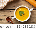 Bowl of tasty Creamy Carrot Soup with vegetables on wooden table,Healthy food.Top view 124233188