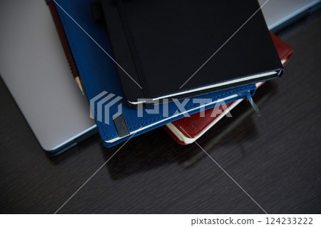 Organized Desk with Stacked Notebooks and Laptop for Productivity 124233222