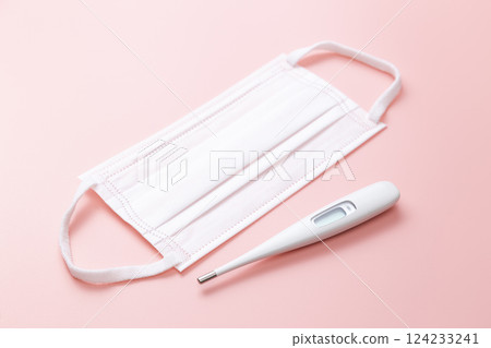 Mask and thermometer on a pink background Mask and thermometer on a pink background 124233241