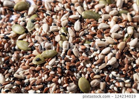 A mixture of different seeds . Sunflower seeds, black and white sesame seeds, flax and pumpkin seeds - all together. Healthy eating. A mixture of different seeds . Sunflower seeds, black and white sesame seeds, flax and pumpkin seeds - all together. Healthy eating. 124234019