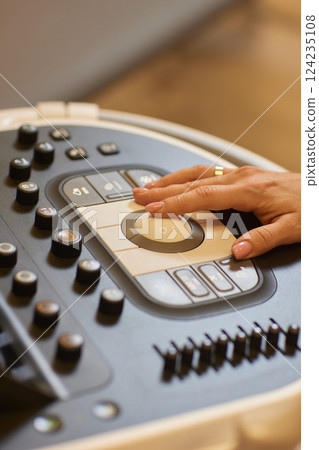 Sonography. Medical ultrasound transducer in doctor's hand, close-up near ultrasound machine in medical clinic 124235108