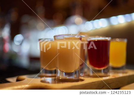 Bartender pouring and serving alcoholic drinks at bar 124235123