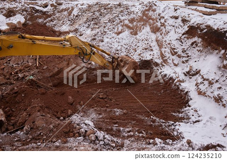 excavator transferring a ground with a heavy bucket into the back side of the truck. excavator transferring a ground with a heavy bucket into the back side of the truck. 124235210