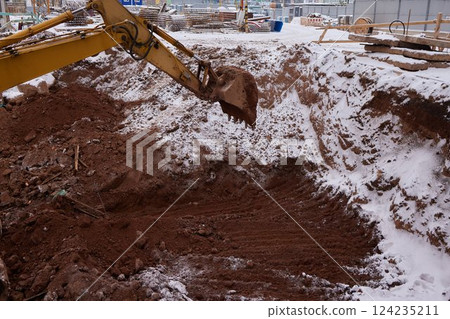 excavator transferring a ground with a heavy bucket into the back side of the truck. 124235211