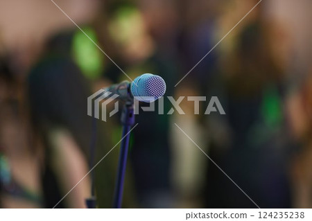 Microphone over the Abstract blurred photo of conference hall or seminar room background Microphone over the Abstract blurred photo of conference hall or seminar room background 124235238