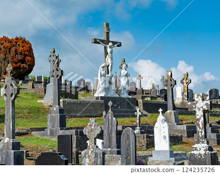 Exploring an ancient Irish cemetery with unique gravestones under a bright blue sky. Exploring an ancient Irish cemetery with unique gravestones under a bright blue sky. 124235726