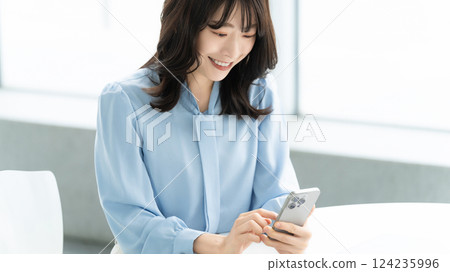 Smiling woman/businesswoman using a smartphone 124235996