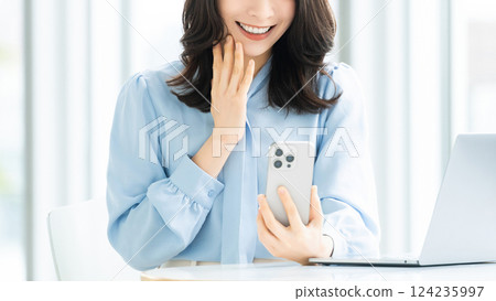 Smiling woman/businesswoman using a smartphone Smiling woman/businesswoman using a smartphone 124235997