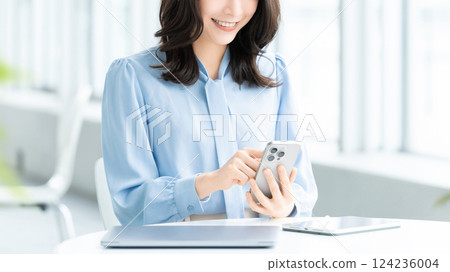 Smiling woman/businesswoman using a smartphone Smiling woman/businesswoman using a smartphone 124236004