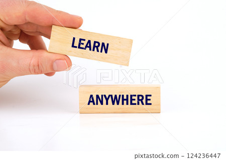 A hand holds a block labeled learn while another block says anywhere, illustrating the flexibility of education in today's world A hand holds a block labeled learn while another block says anywhere, illustrating the flexibility of education in today's world 124236447