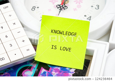 A calculator rests beside a clock and a colorful background while a note states that knowledge is love, emphasizing the connection between learning and success A calculator rests beside a clock and a colorful background while a note states that knowledge is love, emphasizing the connection between learning and success 124236464