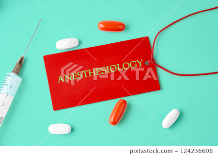 Red tag displaying anesthesiology next to colorful pills and a syringe on a bright turquoise surface Red tag displaying anesthesiology next to colorful pills and a syringe on a bright turquoise surface 124236608