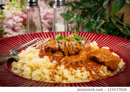 Chunky beef stew with savory sauce, served with bulgur groats. Chunky beef stew with savory sauce, served with bulgur groats. 124237608