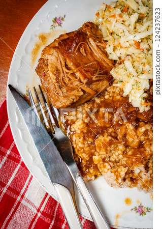 Braised pork in a spicy sauce served with bulgur and sauerkraut salad. 124237623