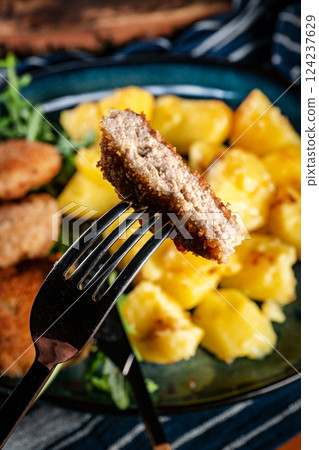 Meatballs with cheese served with boiled potatoes. 124237629