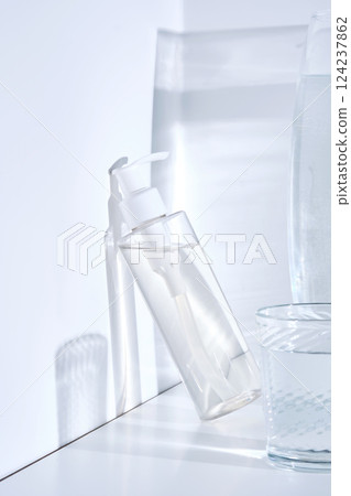 Bottle of cosmetic skin care product on white background with water reflections. Bottle of cosmetic skin care product on white background with water reflections. 124237862