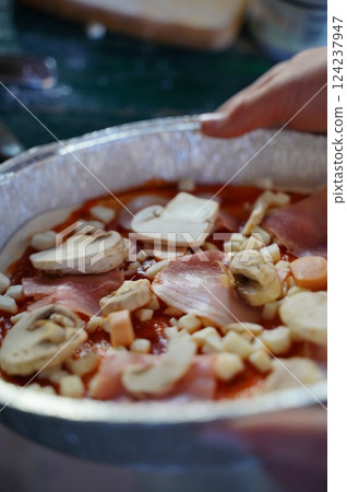 Preparing Homemade Pizza with Mushrooms and Ham Toppings Preparing Homemade Pizza with Mushrooms and Ham Toppings 124237947