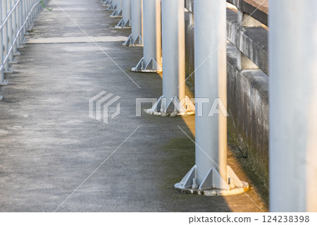 Close up base of Electric poles on Pedestrian pathway or corridor or hallway between train station and other building. 124238398