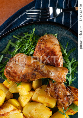 Baked chicken drumsticks with potatoes. 124238716