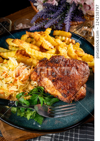 Crispy roasted chicken piece with french fries and salad. 124238797