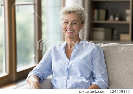 Portrait happy senior woman sitting on cozy couch with smile Portrait happy senior woman sitting on cozy couch with smile 124239523