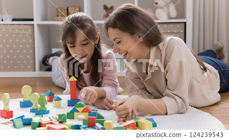 Loving mom playing with toy construction set with young daughter Loving mom playing with toy construction set with young daughter 124239543