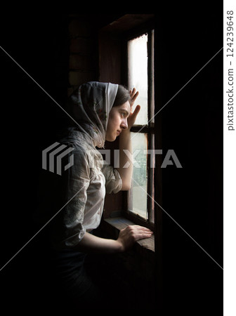 Girl stands at the window 124239648