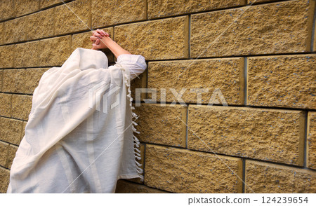 Young woman pray at the wall 124239654