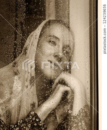 Young girl at the window Young girl at the window 124239656