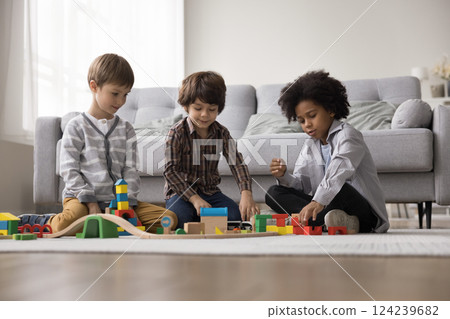 Little Black boy playing with railroad set with foster brothers Little Black boy playing with railroad set with foster brothers 124239682