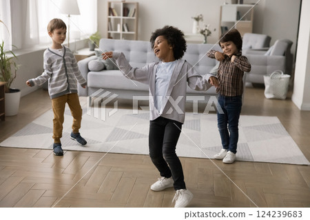 Adorable active little multiethnic brothers dance at living room together Adorable active little multiethnic brothers dance at living room together 124239683