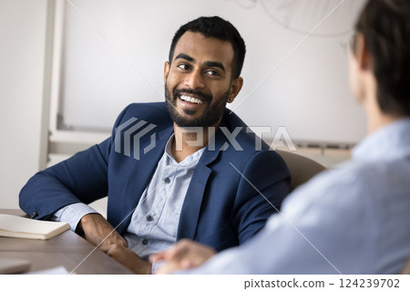 Businessman sit at desk with company client, participating in negotiations Businessman sit at desk with company client, participating in negotiations 124239702