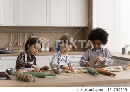 Multiethnic group three happy little boys baking cookies at home 124239719