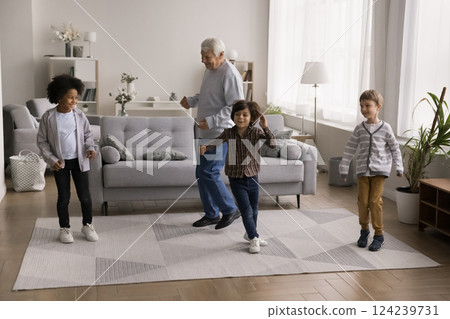 Multiethnic little boys laugh dance in living room with grandpa 124239731