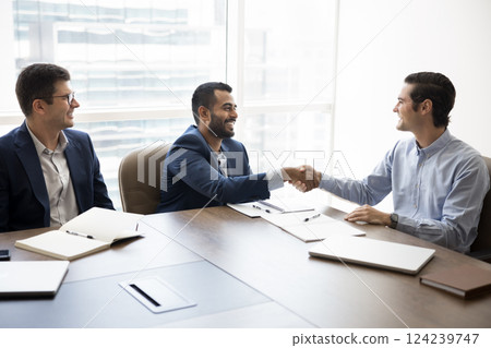 Business partners shaking hands, reaching agreement, closing profitable commercial deal 124239747