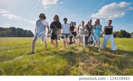 High school students embrace unity and friendship as they walk through a summer field holding hands High school students embrace unity and friendship as they walk through a summer field holding hands 124239983