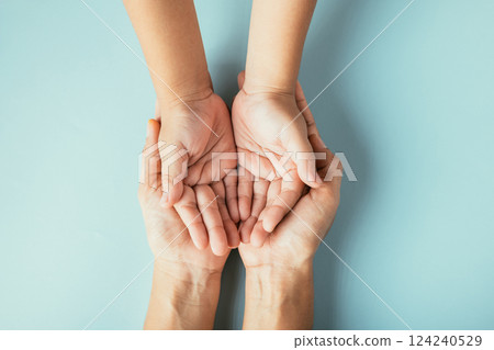 Top view studio shot of family hands stacked isolated background. Parents and kid hold empty space symbolizing support on Family and Parents Day. Top view studio shot of family hands stacked isolated background. Parents and kid hold empty space symbolizing support on Family and Parents Day. 124240529