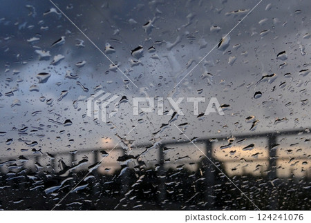 Metal Railing of Bridge is Visible Through Drops Pattern on Window  124241076