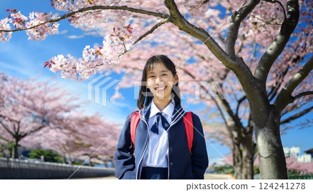 A high school girl stands under a cherry tree at the start of the new semester. 124241278