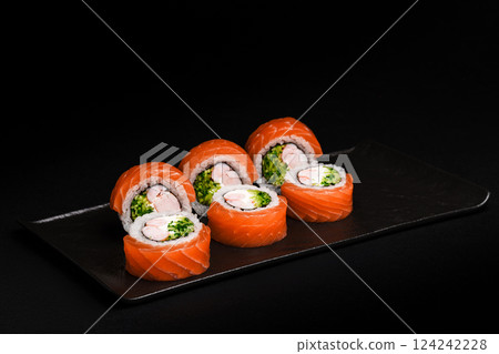 Delicious Fresh Salmon Sushi Rolls Presenting Exquisitely on a Black Background 124242228